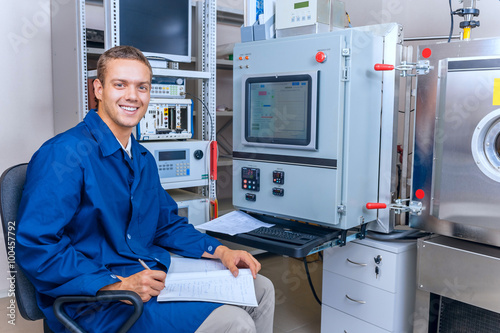 Smiling engineer working with the equipment in the science laboratory
