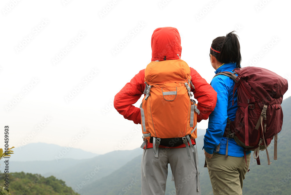 two successful backpacker enjoy the beautiful landscape at mountain peak