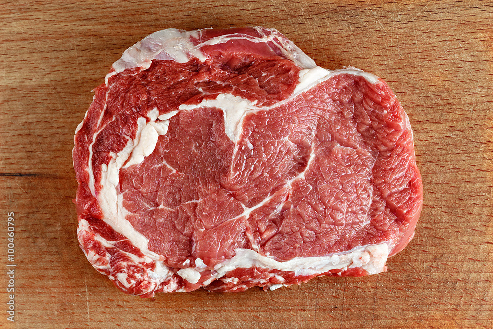 Fototapeta premium Raw ribeye steak on a cutting board
