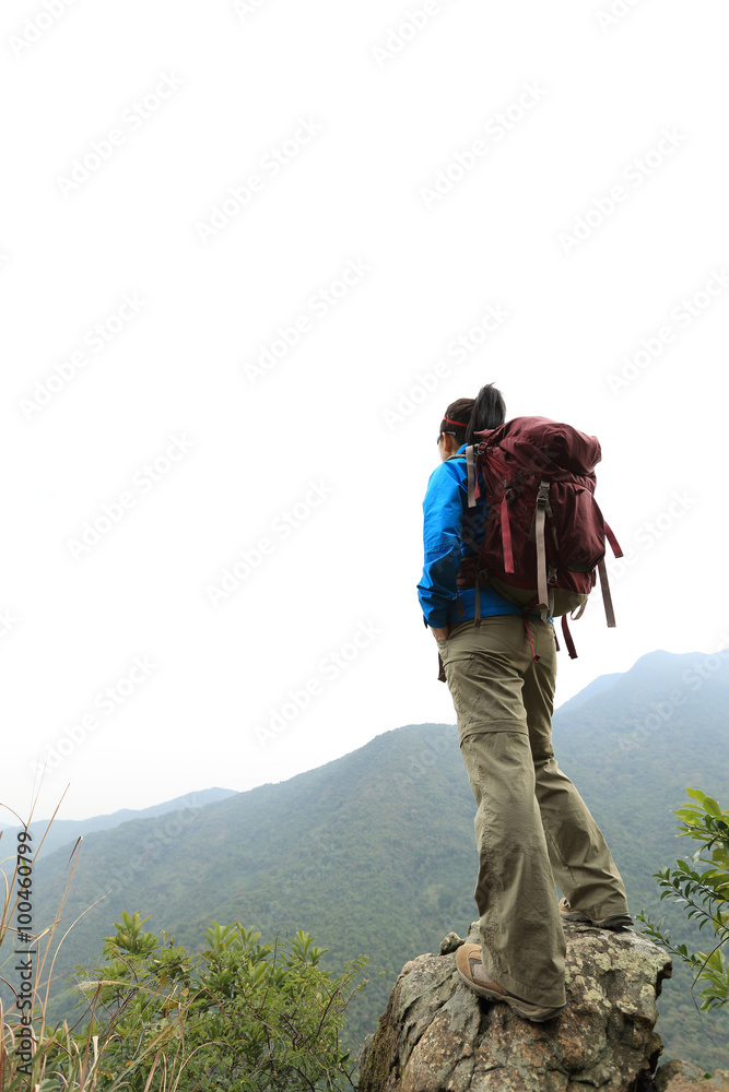 young woman backpacker hiking at mountain peak