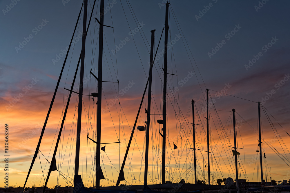 Silhouettes of masts at sunset in the main harbor of Kos island, Greece