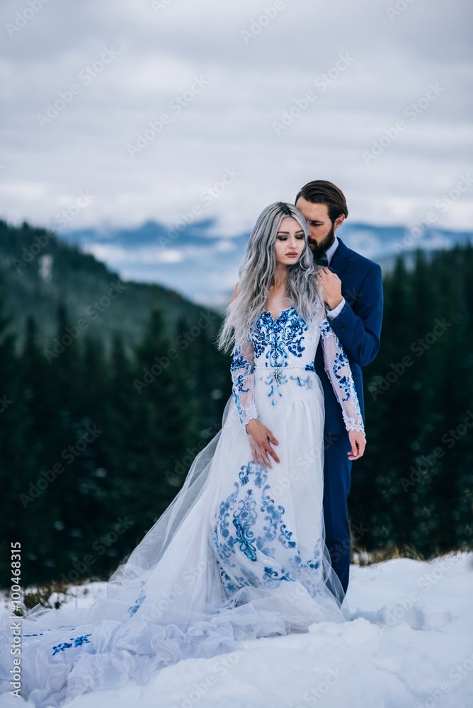 groom in a blue suit and bride in white in the mountains Carpath groom in a blue suit and bride in white in the mountains Carpath
