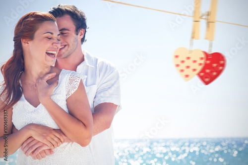 Composite image of happy couple hugging and laughing together photo