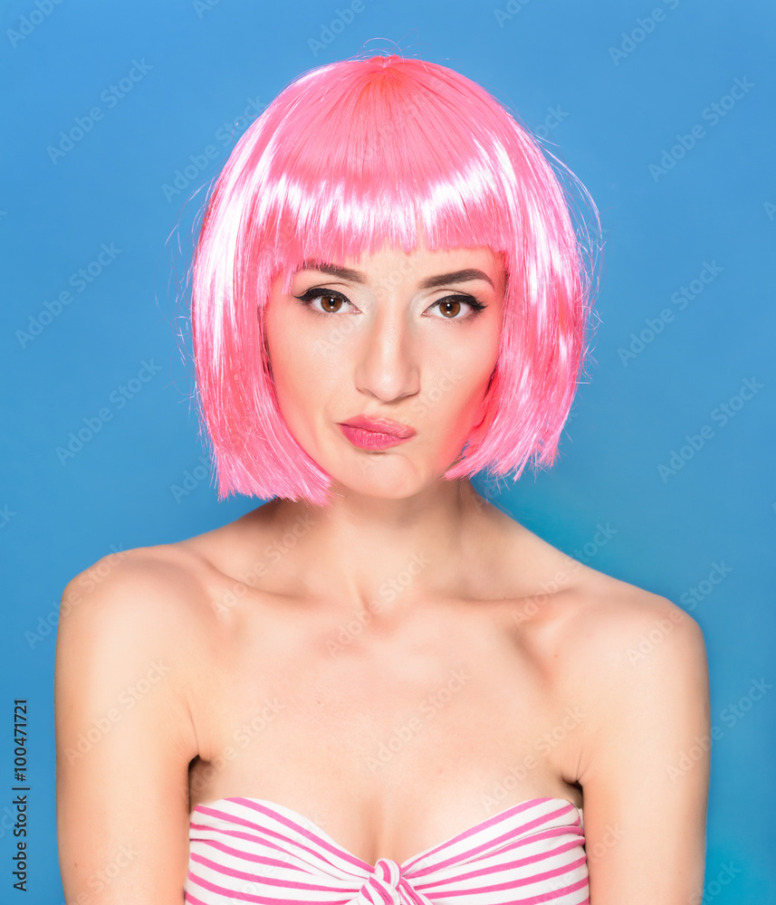 Confused young woman with pink hair on a blue background Confused young woman with pink hair on a blue background