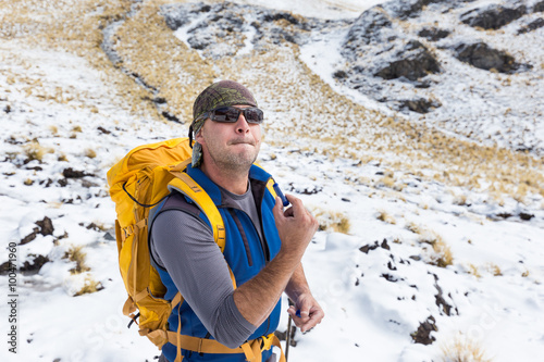 Man backpacker tourist using lipstick, Condoriri mountains Boliv photo