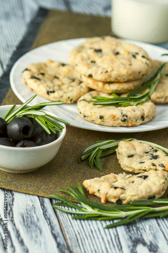 Cookies with cheese, olives and rosemary on napkin