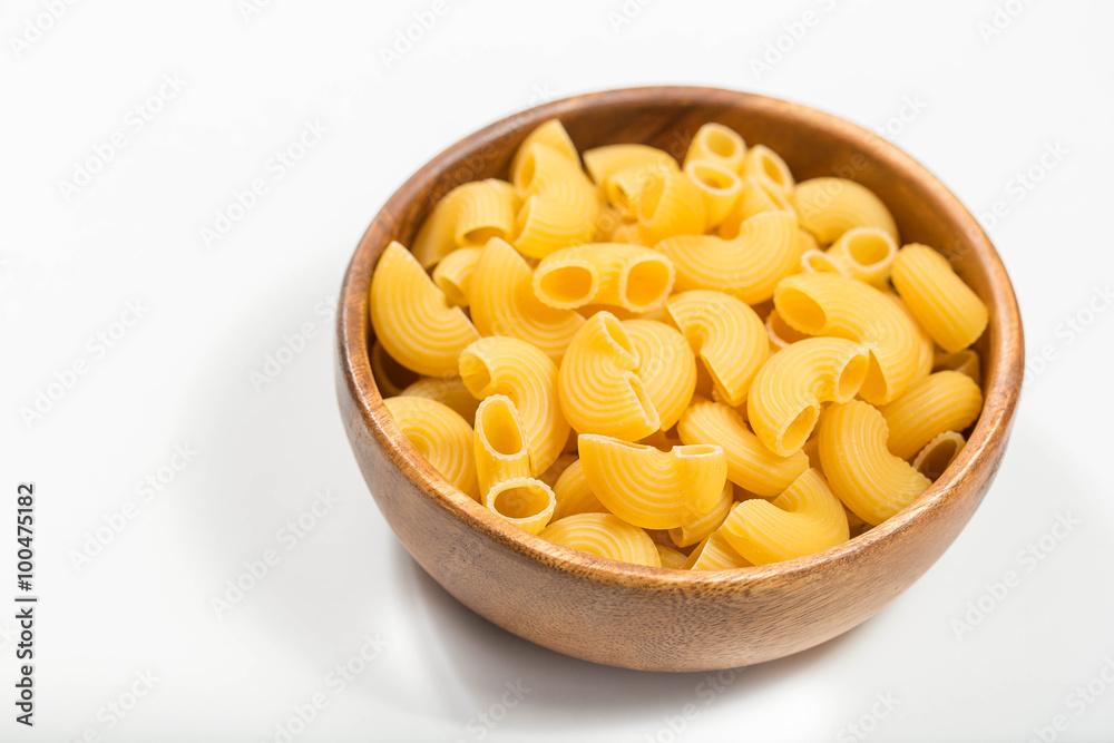 Raw uncooked pasta in bowl Raw uncooked pasta in bowl