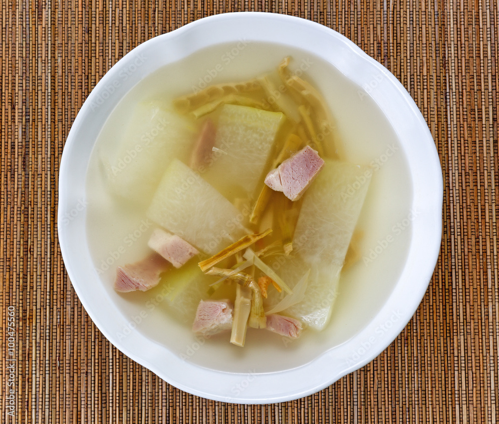 Fresh pork and cabbage soup on bamboo mat background