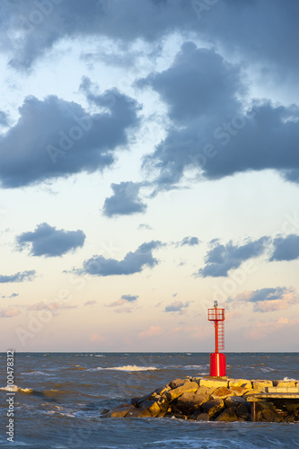 A littel red lighthouse with cloudy sky