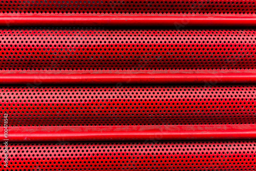 Close up of red metal shutters protecting shop frontage