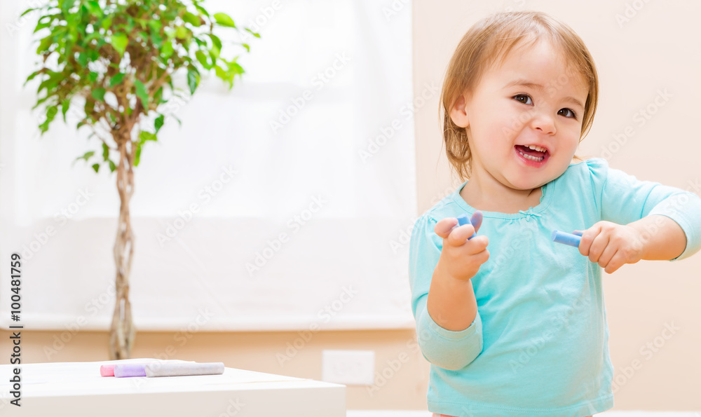 Happy toddler girl playing with chalk Happy toddler girl playing with chalk