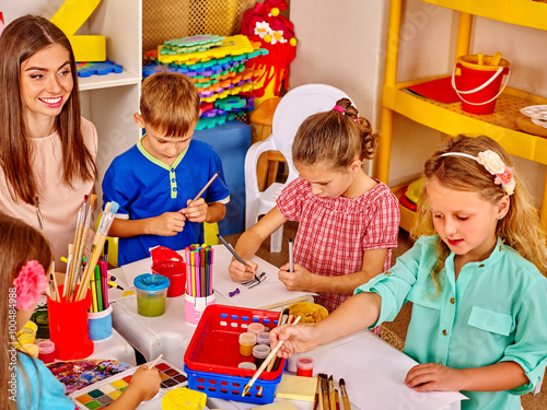 Group kids with teacher woman learnig painting on paper  in  kindergarten .  photo