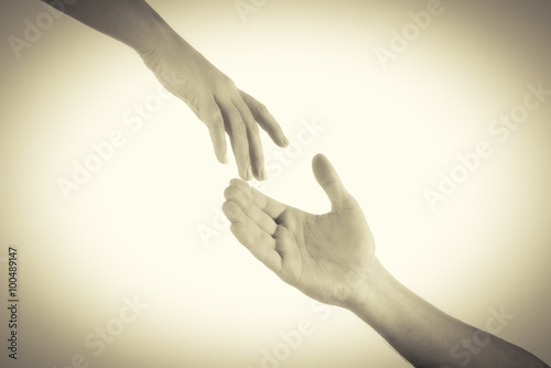 Φωτογραφία Two hands reaching toward each other