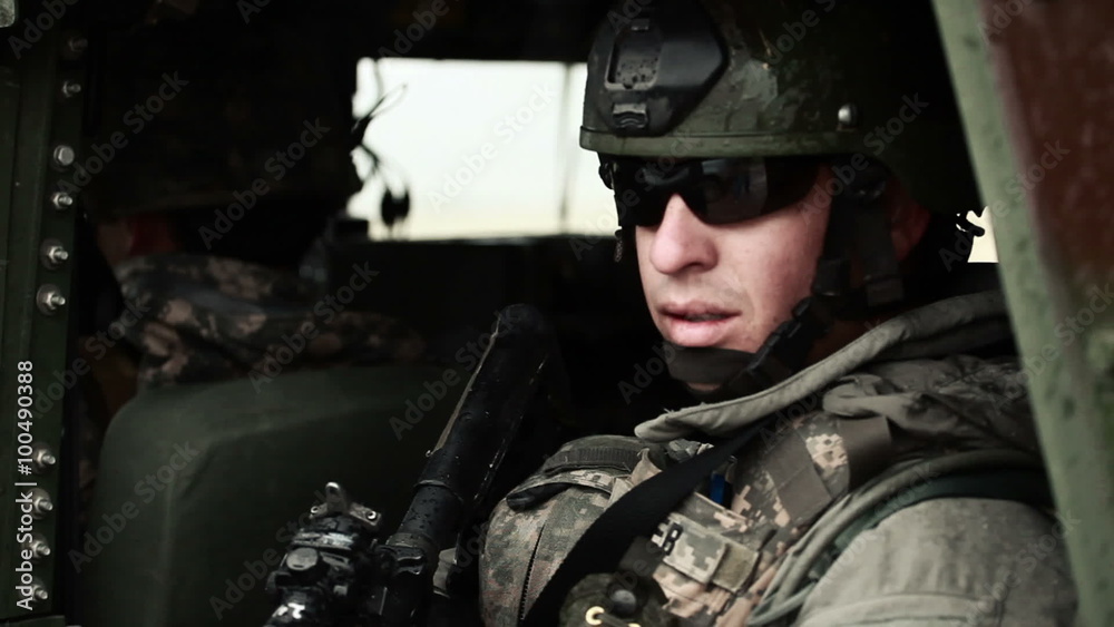 Soldier wearing sunglasses looking out side door of Humvee. Soldier wearing sunglasses looking out side door of Humvee.