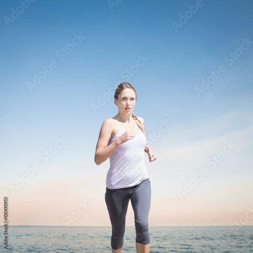 Composite image of focused fit blonde jogging 