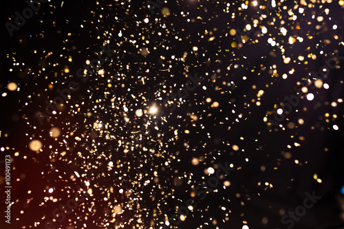 Photo of golden glitter on a black background. Golden explosion
