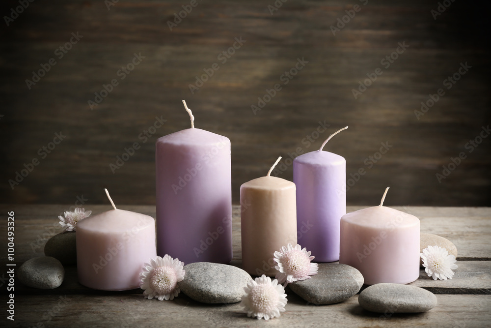 Spa set with candles, pebbles and flowers on wooden background
