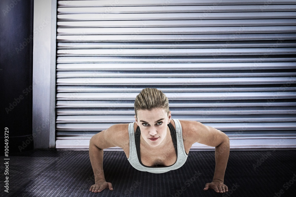 Composite image of muscular woman doing push-ups Composite image of muscular woman doing push-ups