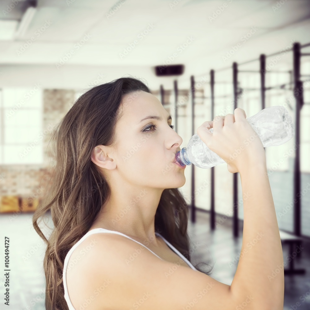 Composite image of beautiful woman drinking water from bottle Composite image of beautiful woman drinking water from bottle