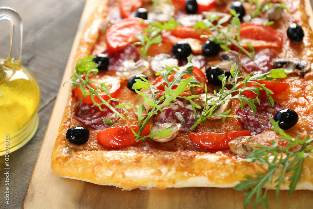Rectangle delicious pizza and vegetables on the table, close-up Rectangle delicious pizza and vegetables on the table, close-up
