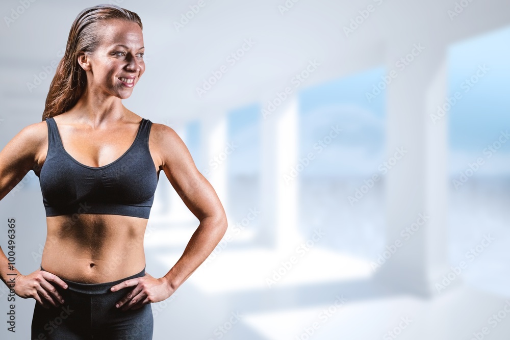 Composite image of cheerful athlete with hands on hip