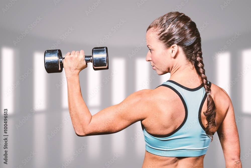 Composite image of rear view of woman lifting dumbbell Composite image of rear view of woman lifting dumbbell