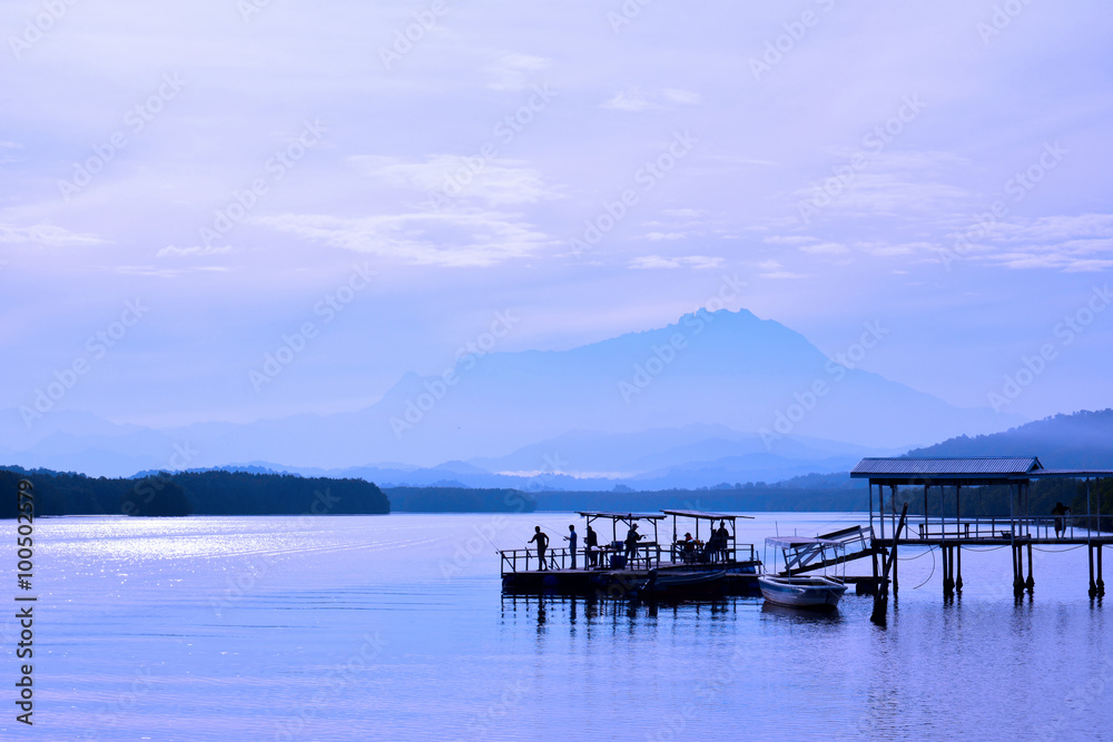 View of Mount Kinabalu in the far horizon seen from the Jetty Mengkabong, Sabah Borneo, Malaysia. After sunrise.