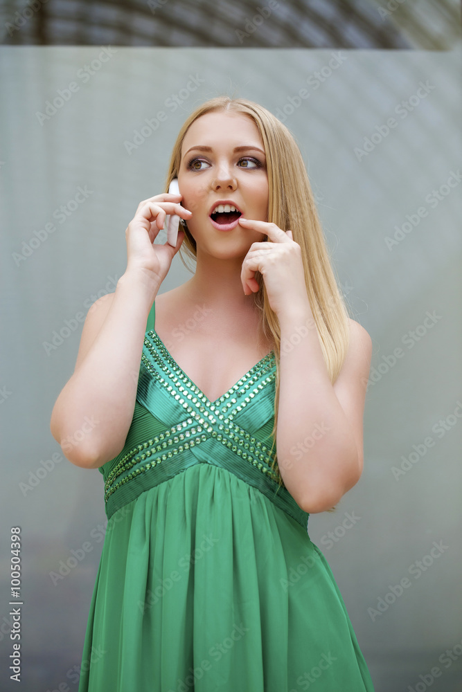 Young beautiful girl in the green dress talking on cell phone Young beautiful girl in the green dress talking on cell phone