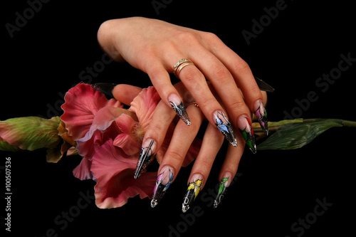 Pretty woman hand with perfect painted nails isolated on black background