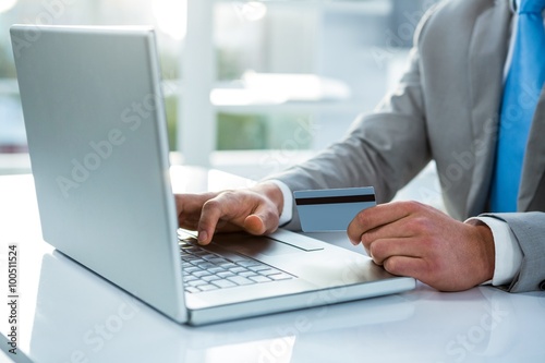 Businessman holding his credit card to pay