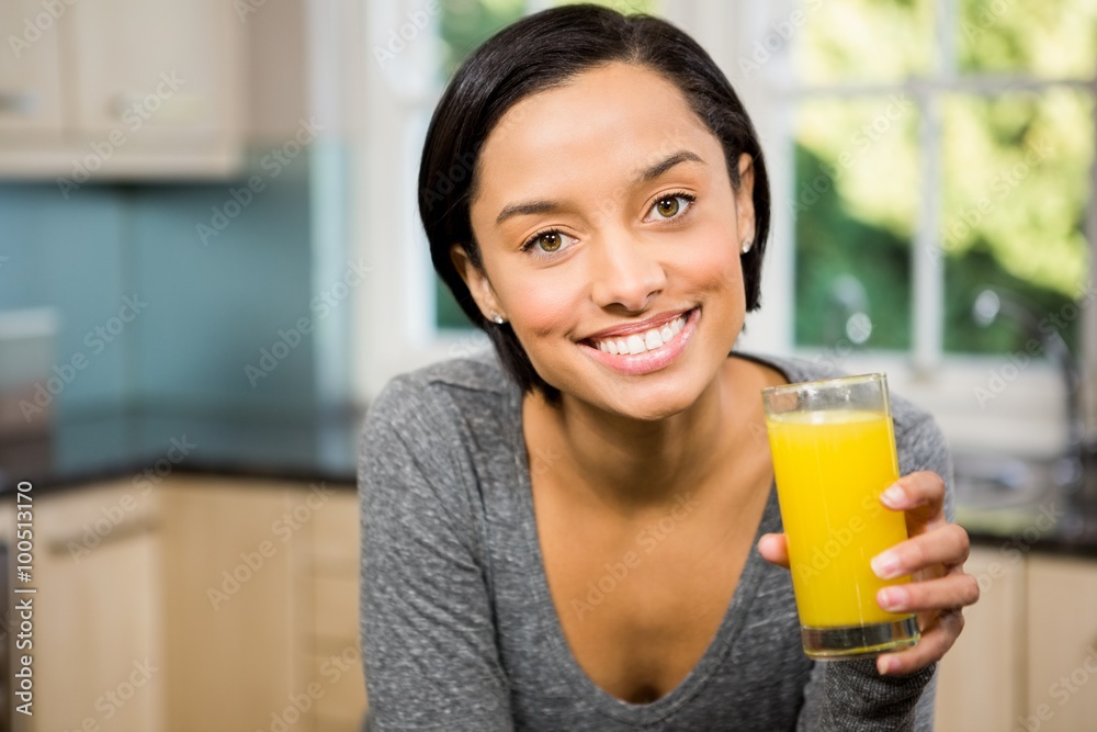 Smiling brunette holding glass of orange juice Smiling brunette holding glass of orange juice