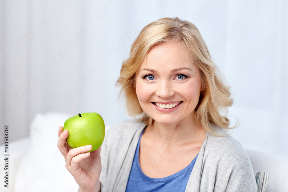 happy middle aged woman with green apple at home happy middle aged woman with green apple at home