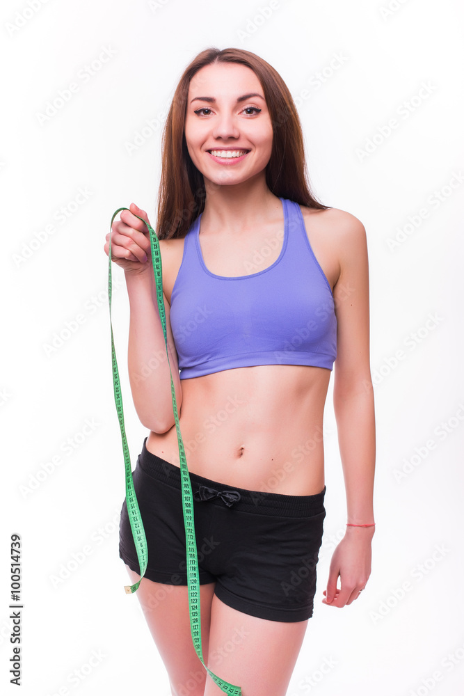 Fit and healthy young lady measuring her waist with a tape measure in centimeters and millimeters. Isolated image on white.