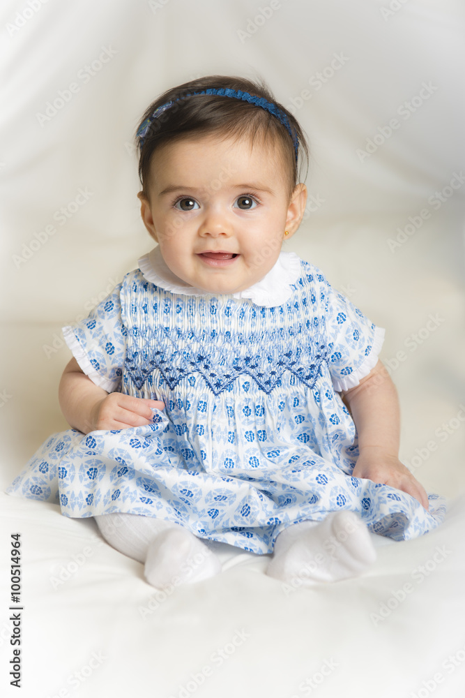 Bebé niña simpática sonriente sentada sobre una colcha de cama suave Stock  Photo | Adobe Stock