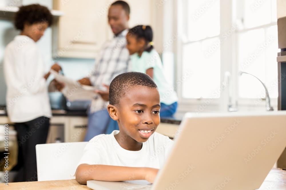 Son using laptop in the kitchen Son using laptop in the kitchen