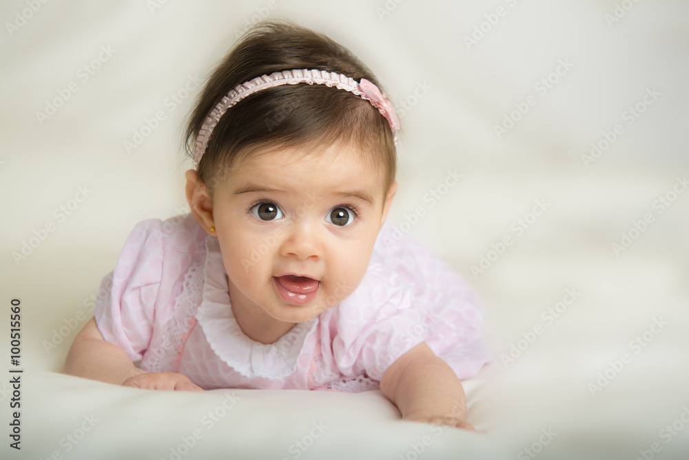 Bebé niña con bonita sonrisa gateando por primera vez sobre una cama Stock  Photo