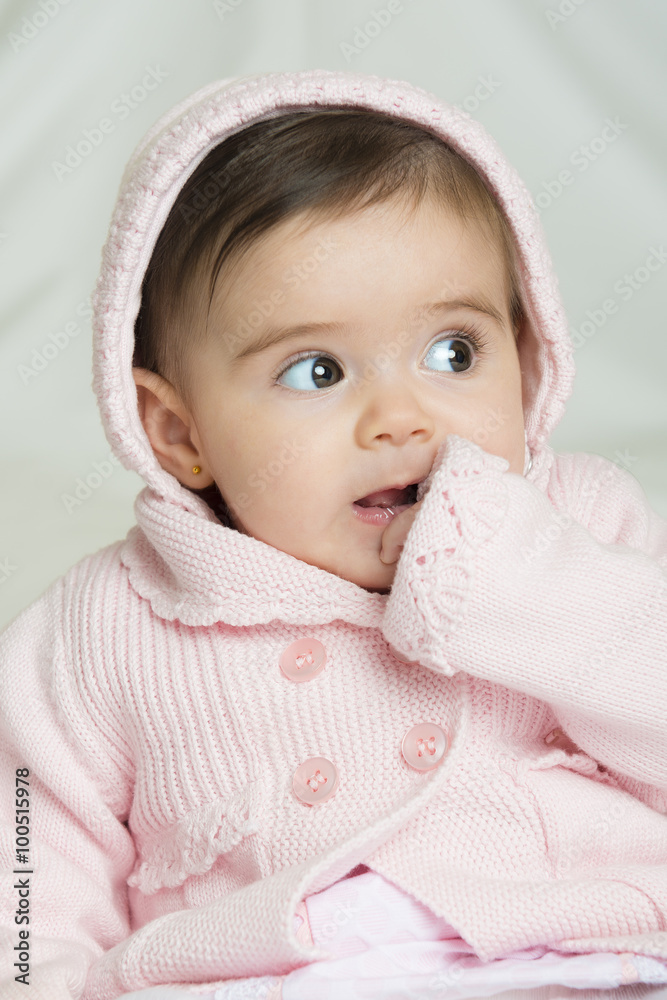 Bebé niña simpática sonriente sentada sobre una colcha de cama suave Bebé niña simpática sonriente sentada sobre una colcha de cama suave