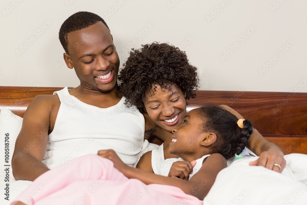 Obraz premium Happy family lying in bed together