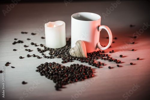 horizontal still life of mugs of coffee  coffee beans  and hearts of wood in warm brown tones