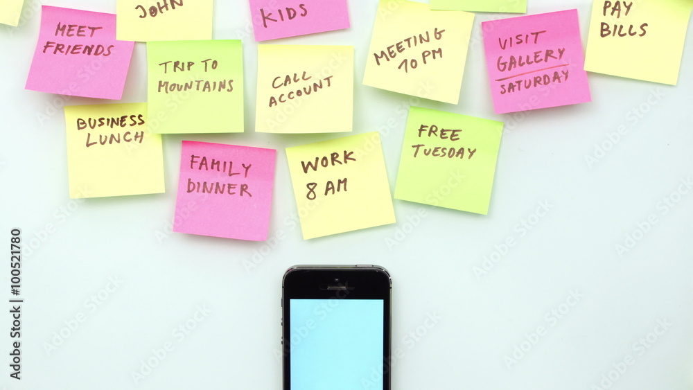 Office desk with smart phone, post it papers and different handwritten notes