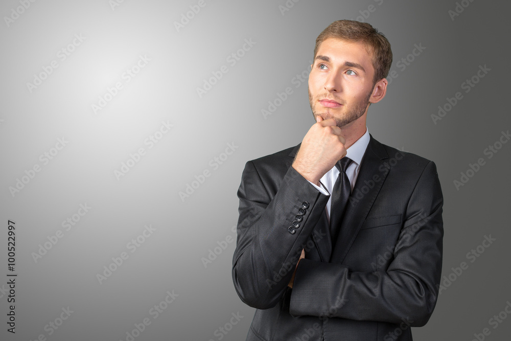 Confused young businessman thinking