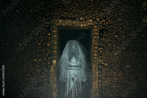 Frightening ghost in a catacomb full of bones