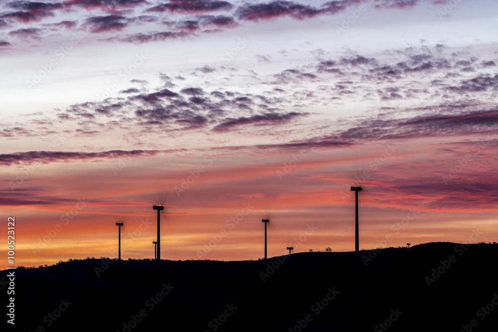 Silhouettes of windmills at dawn