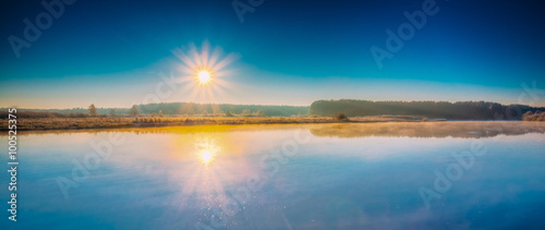 Fototapeta Naklejka Na Ścianę i Meble -  Panorama of sun rises over river. Autumn frost frozen river cove