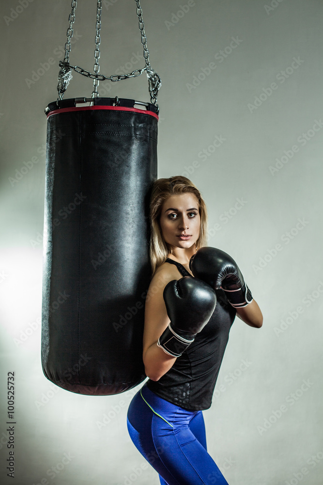 Sexy woman boxer near the boxing bag.