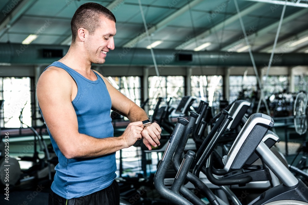 Smiling muscular man using stopwatch Smiling muscular man using stopwatch