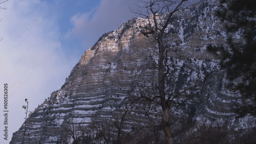 Time lapse of clouds throwing shadows against mountain face