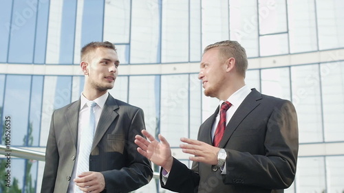 Two businessmen going along office building