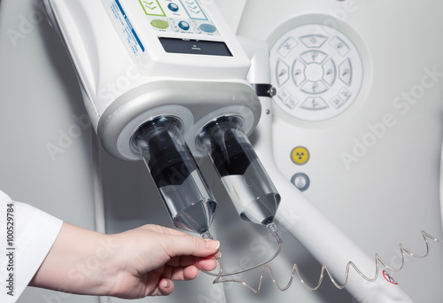 A female doctor's hand on contrast injector