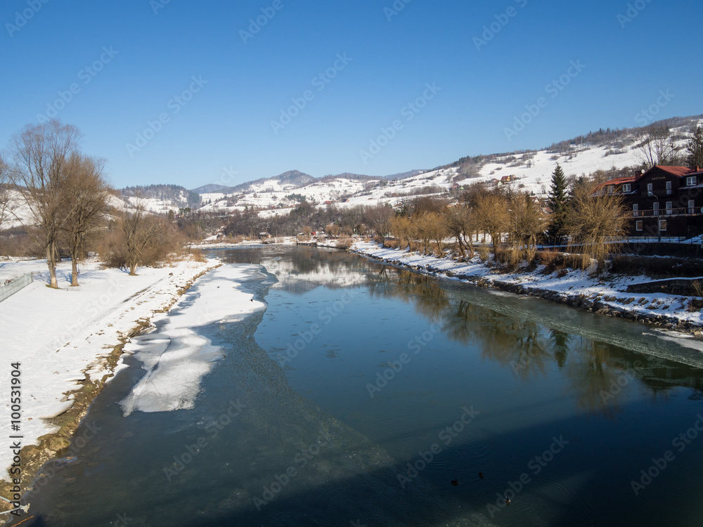 Rzeka Poprad w zimowej szacie przepływająca przez Piwniczna-Zdrój